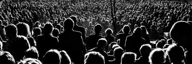 a large group of people standing in front of a stage with the words berlin koseglu on it