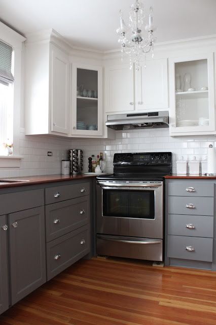 a kitchen with gray cabinets and white walls