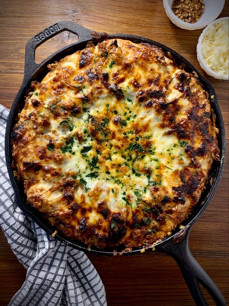 a pizza sitting on top of a pan covered in cheese and toppings next to other dishes