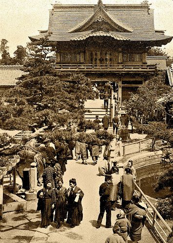 an old black and white photo of people standing in front of a building with trees