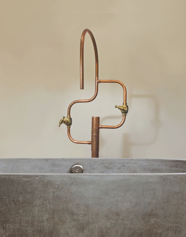 a large metal sink with two faucets on it's sides and a towel rack in the middle