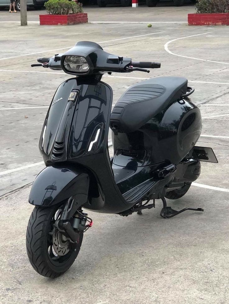 a black scooter parked in a parking lot