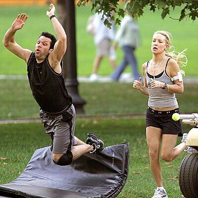 a man and woman playing frisbee in the park