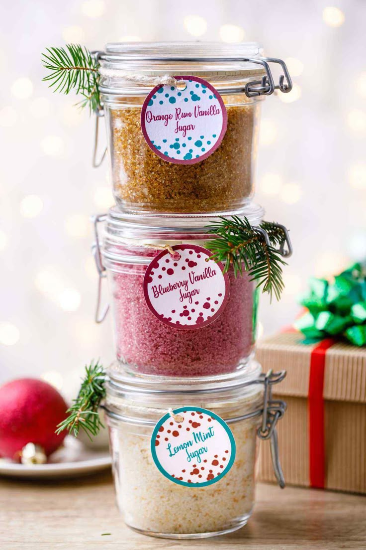 three glass jars filled with different types of seasoning next to a christmas ornament