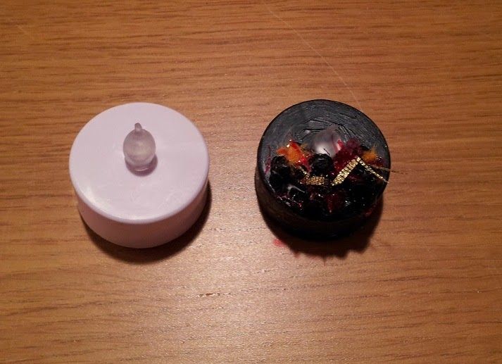 an empty container sitting on top of a wooden table next to a small white object