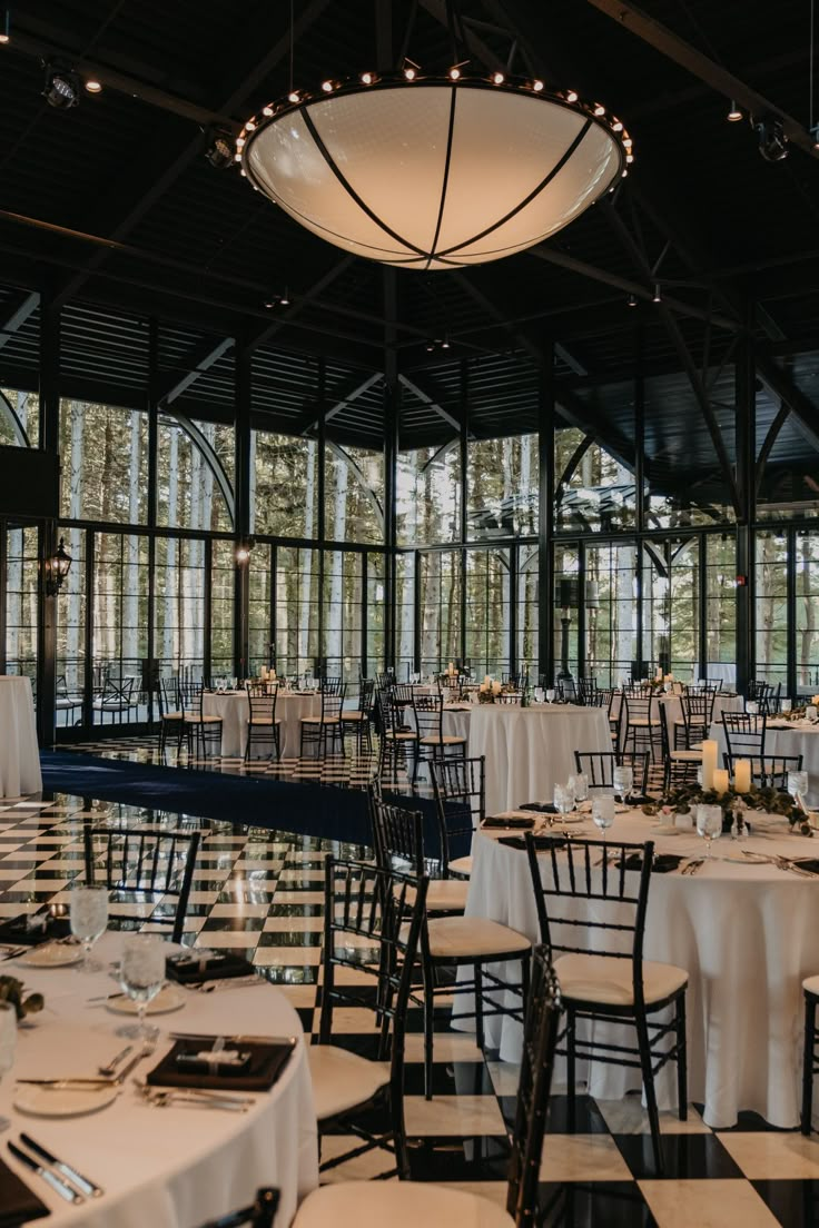 tables and chairs are set up for an event in a large room with black and white checkered flooring