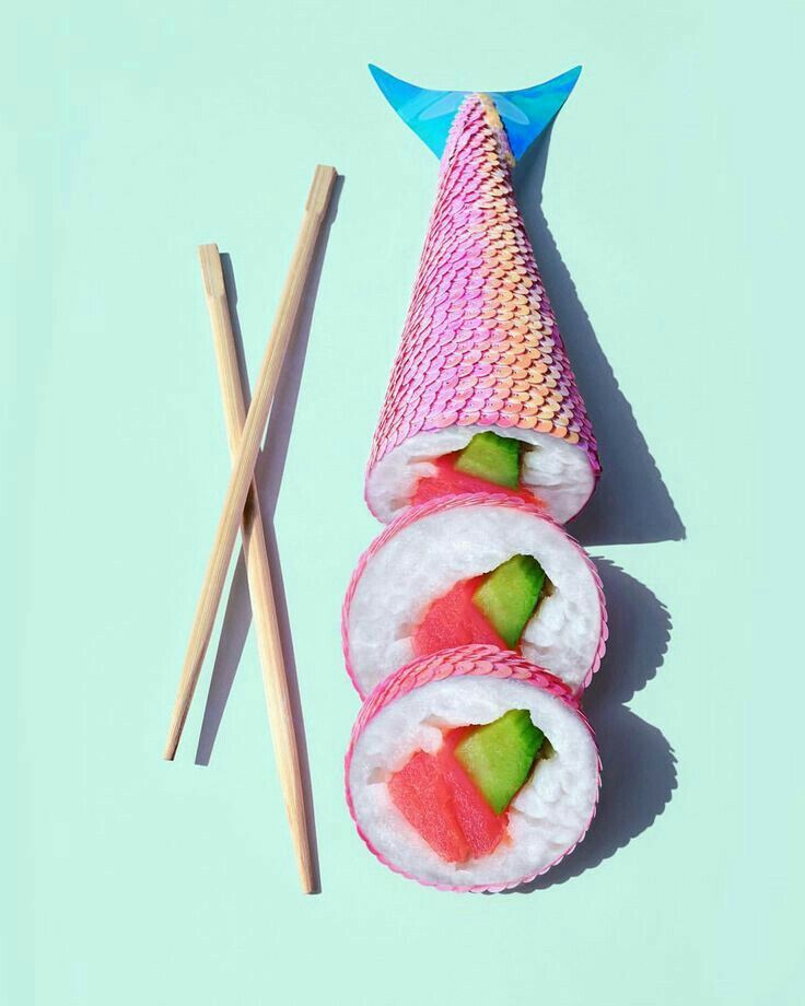 sushi and chopsticks on a white surface