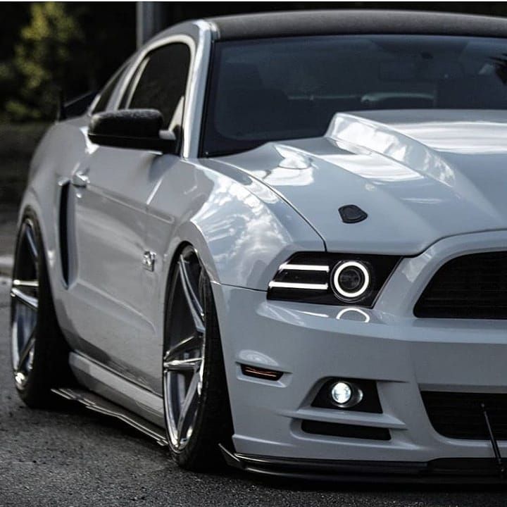 the front end of a white mustang car