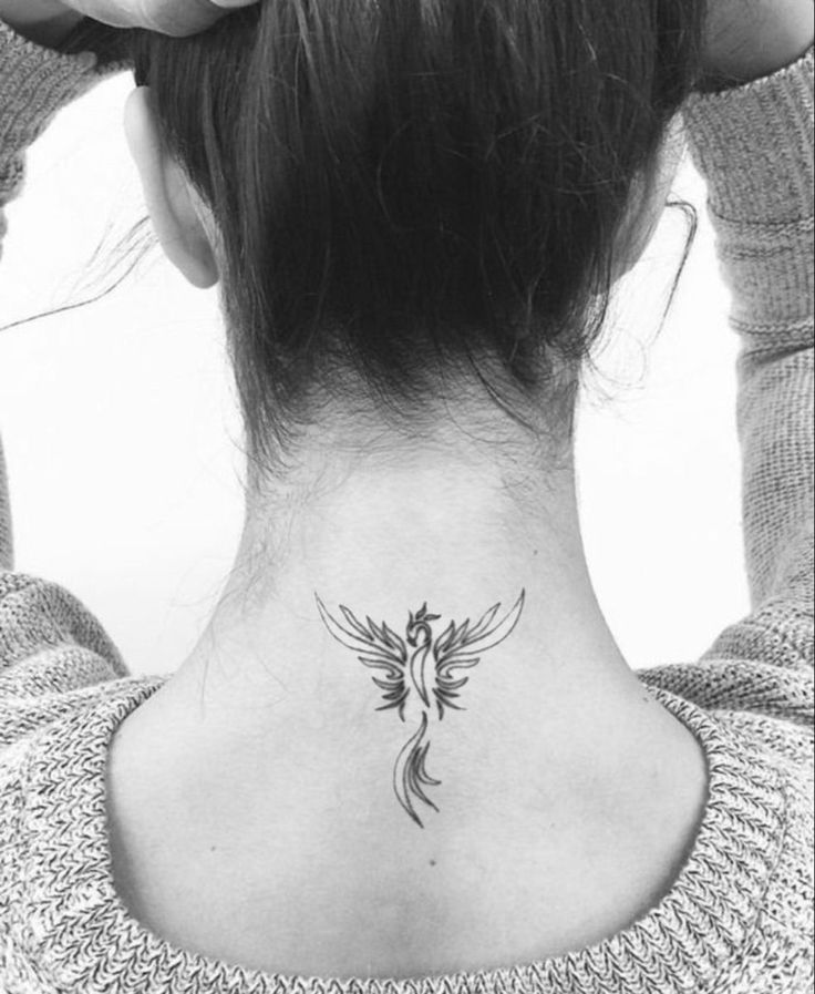 a woman's back neck with a bird tattoo on her left side ribcage