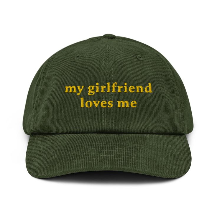 a green hat with the words, my girlfriend loves me on it in gold lettering