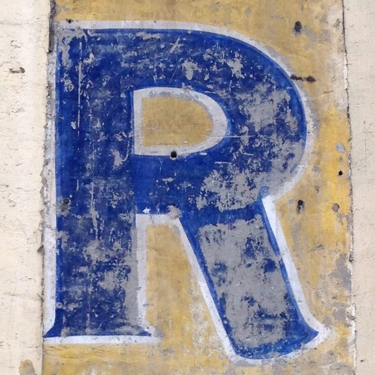 an old blue and yellow sign on the side of a building that reads p is for parking