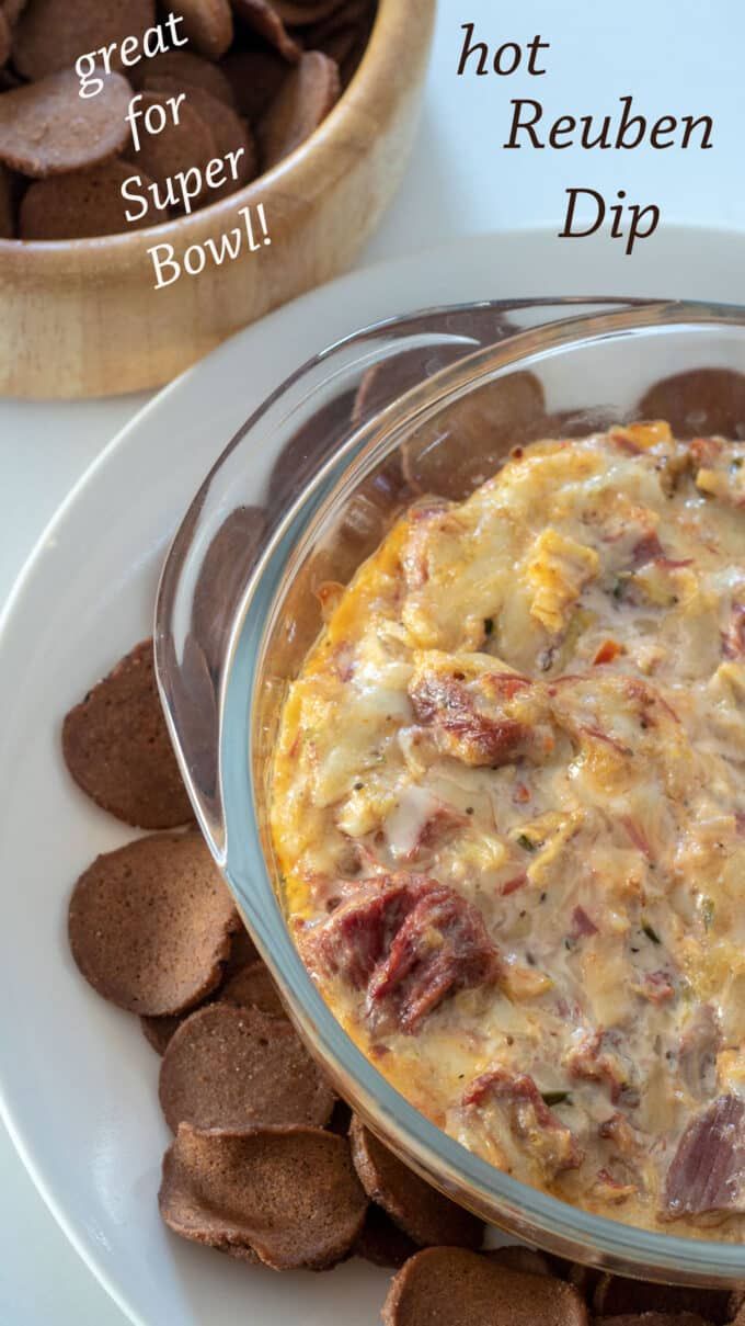 a bowl of dip next to some crackers on a white plate with the words great for super bowl dip