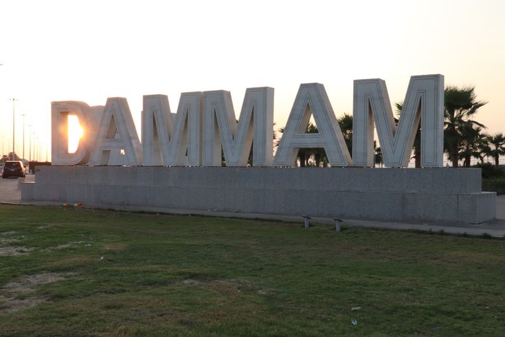 there is a large sign that says dama in front of some grass and trees