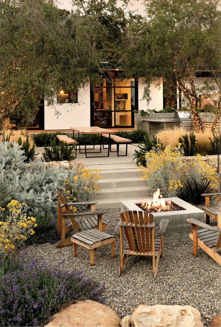 an outdoor fire pit surrounded by wooden chairs