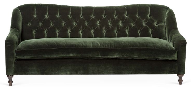 a green velvet couch sitting on top of a white floor