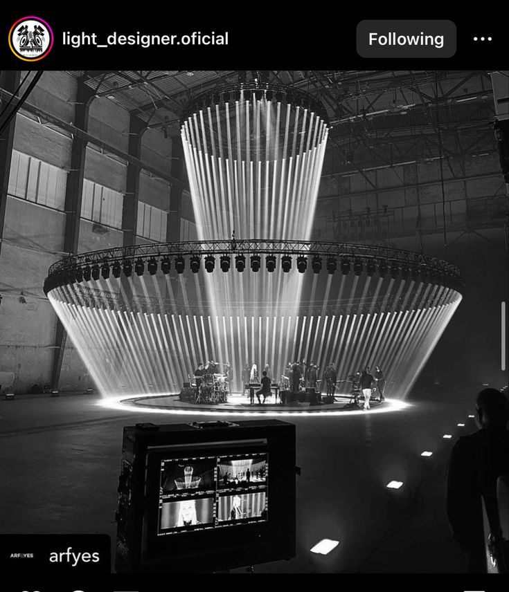 a black and white photo of a large fountain with lights on it's sides