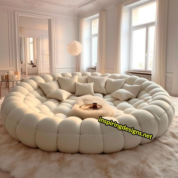 a large white circular couch sitting on top of a fluffy rug in a living room