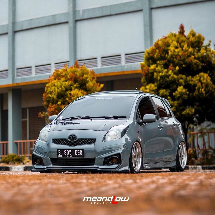 a grey car parked in front of a building