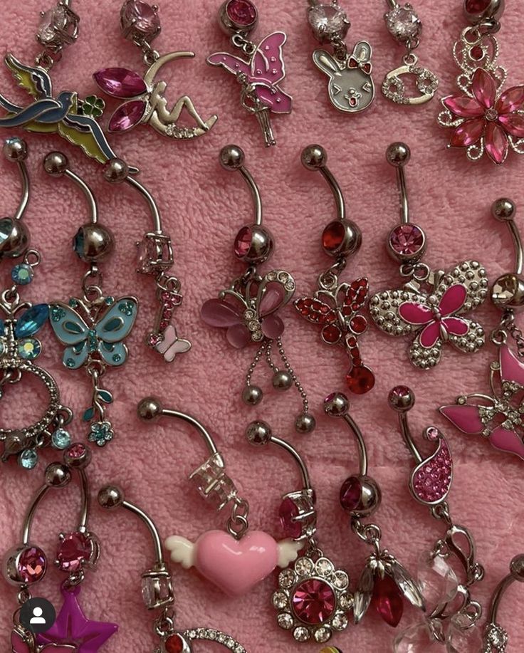 many different types of charms on a pink blanket