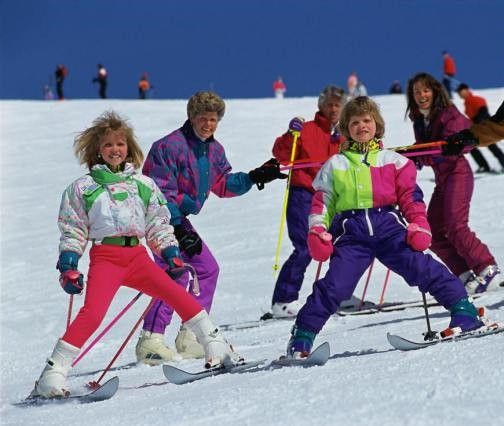 a group of people riding skis on top of a snow covered slope with ski poles