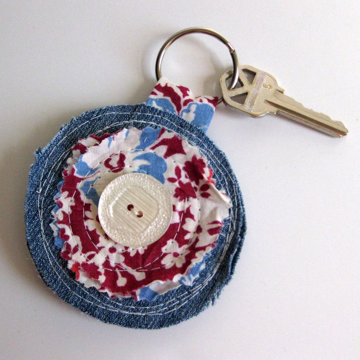 a pair of keys are sitting on top of a piece of fabric with a button in the center