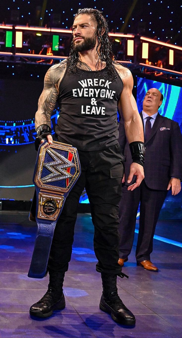 a man with a beard holding a wrestling belt