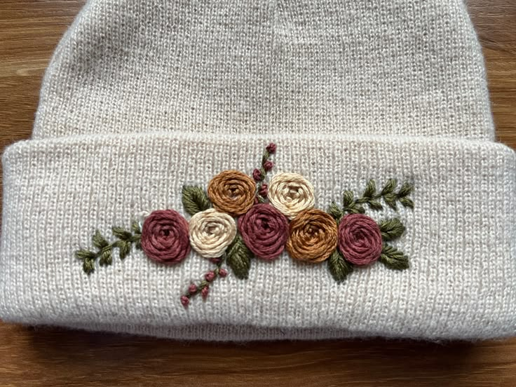 a white knit hat with flowers on it