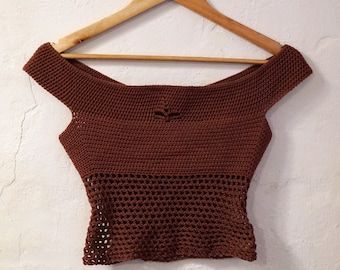 a brown crop top hanging on a wooden hanger