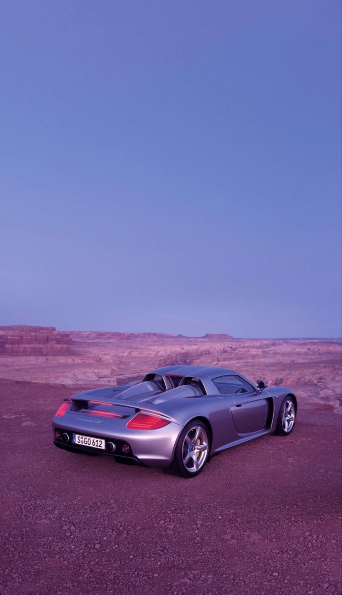 a silver sports car parked in the desert