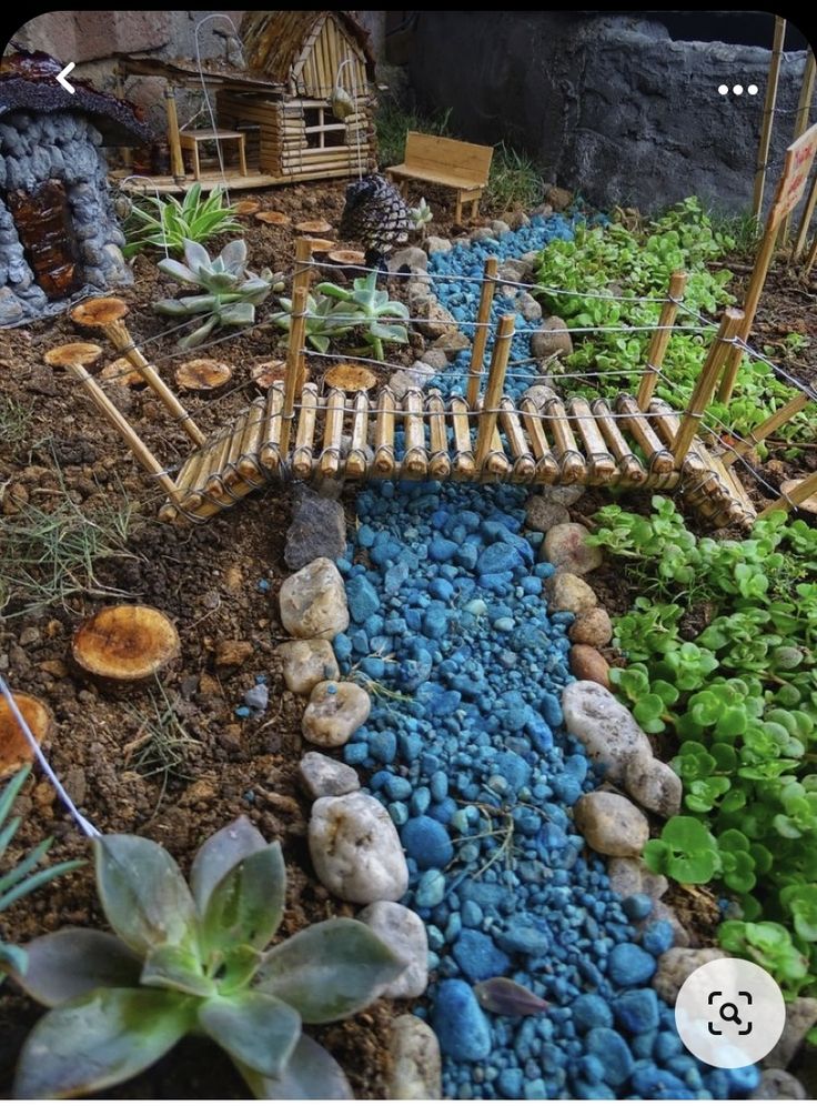 a small garden with rocks and plants in the center, along with a bridge made out of bamboo sticks