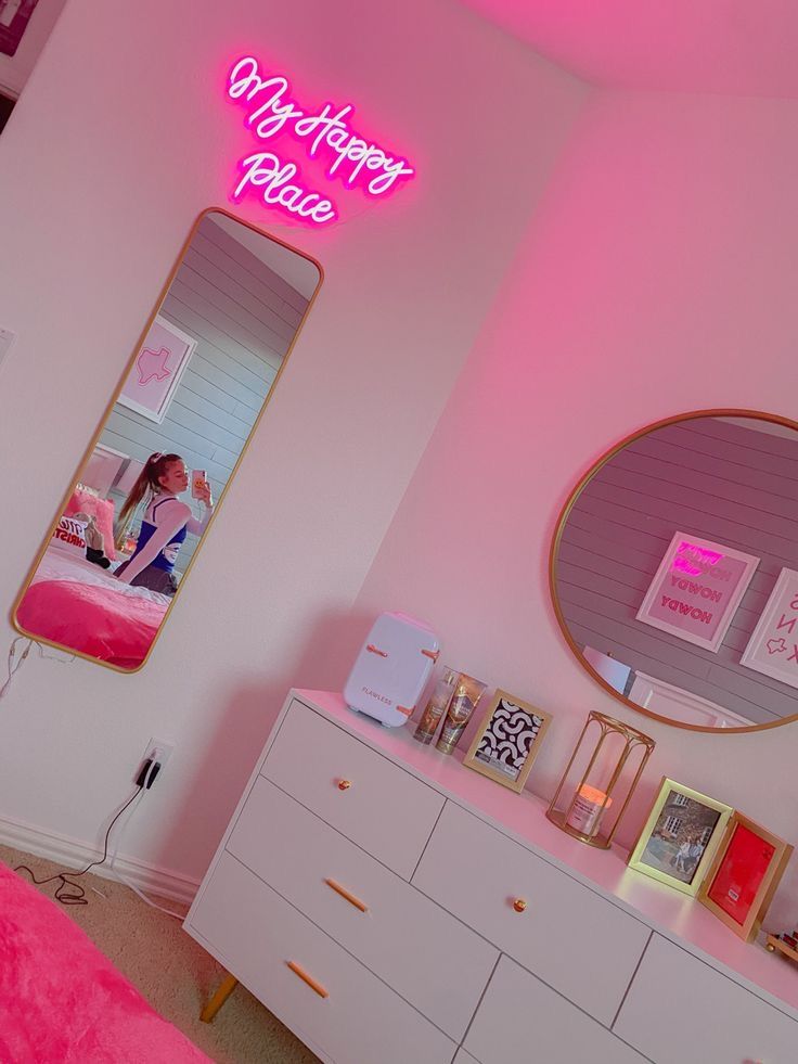 a bedroom with pink walls and white dressers