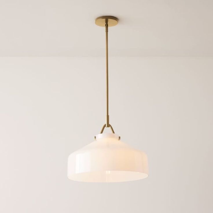 a white light hanging from a ceiling fixture in a living room or dining room area