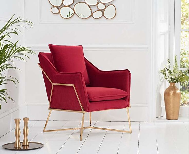 a red chair sitting next to a potted plant