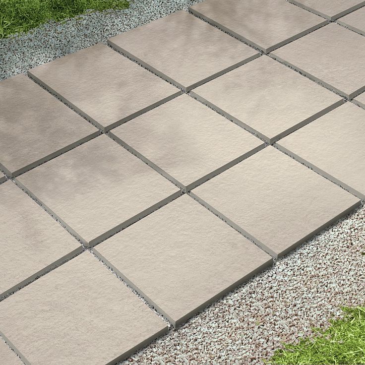 a cement patio with grass and gravel around it