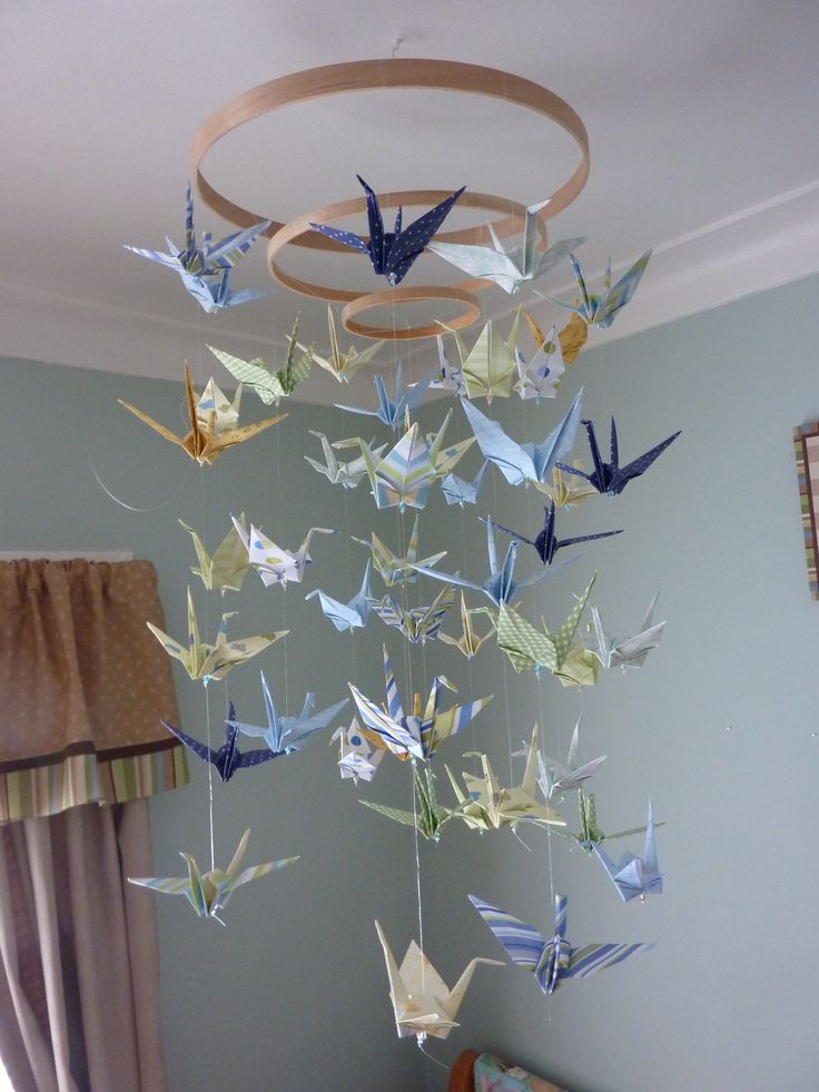 a bed room with a chandelier made out of origami birds hanging from the ceiling