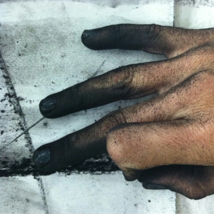 two hands with black nails are shown on the left and right side of the image