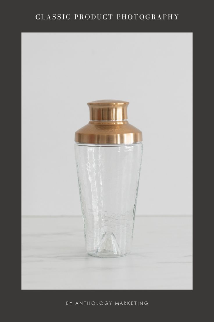 a glass jar with a gold lid sitting on top of a table