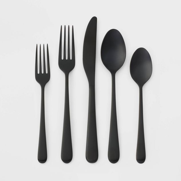 four forks, two spoons and one knife on a white surface with black handles