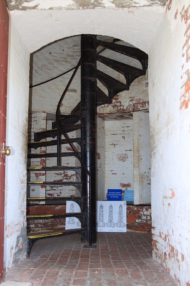 an open doorway with a spiral staircase in the center and brick flooring on both sides