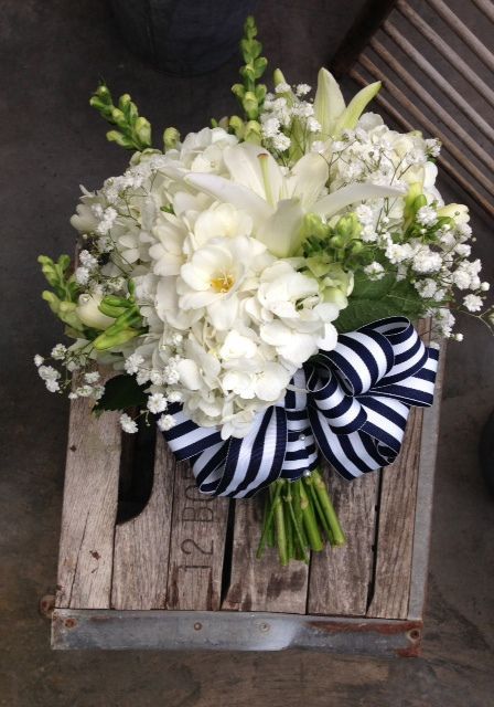 a bouquet of white flowers sitting on top of a wooden crate