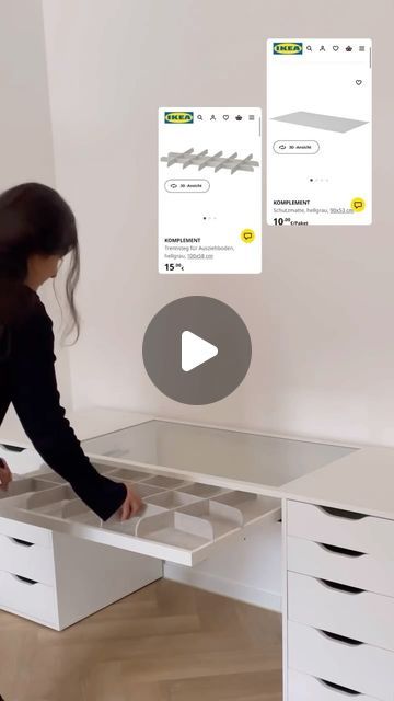 a woman standing in front of a white desk with drawers on each side and one drawer open