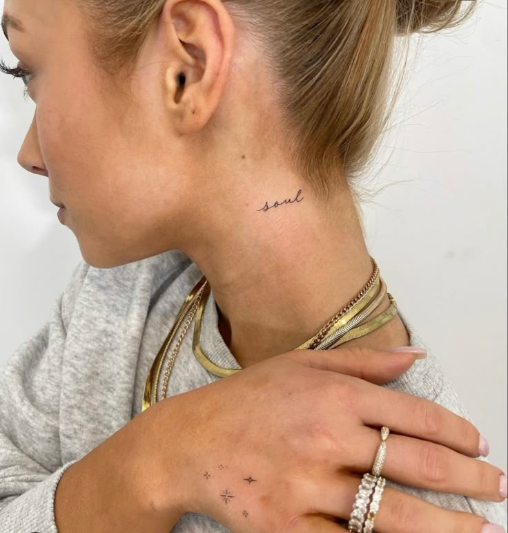 a woman with a small star tattoo on her left side behind her neck and hand