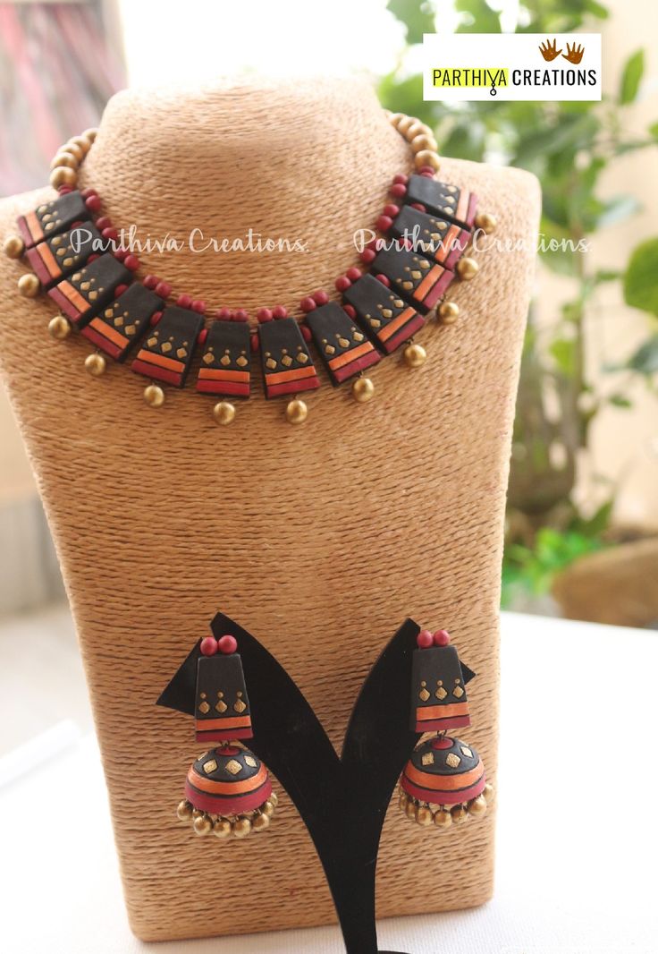 a necklace and earring set is displayed on a mannequin headdress