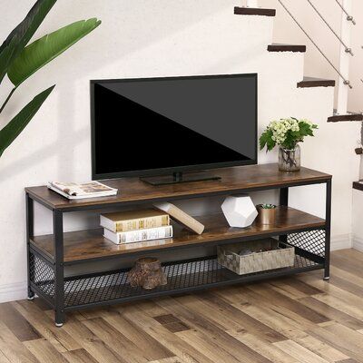 a flat screen tv sitting on top of a wooden shelf next to a stair case