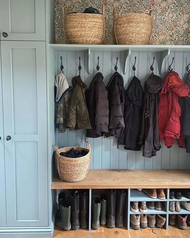 a coat rack filled with coats and shoes next to a wall mounted shoe storage unit