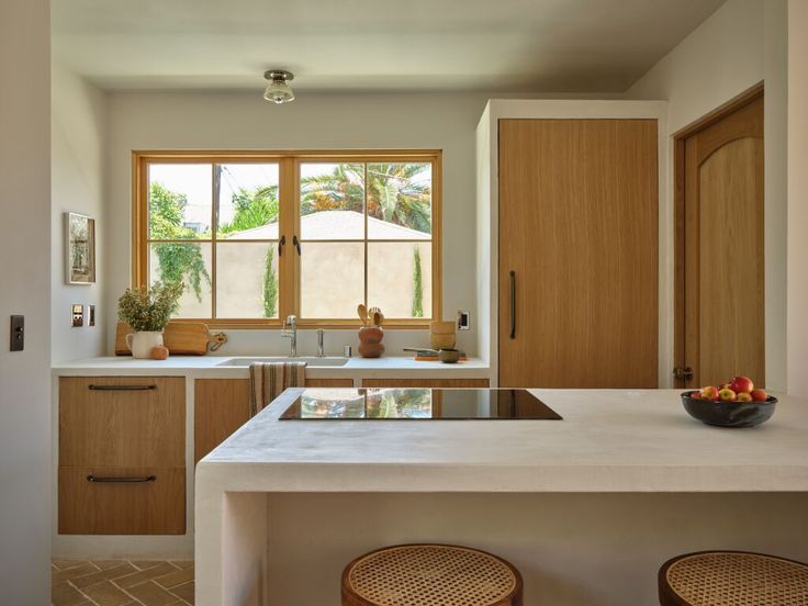 a kitchen with two stools next to a counter top and an island in the middle