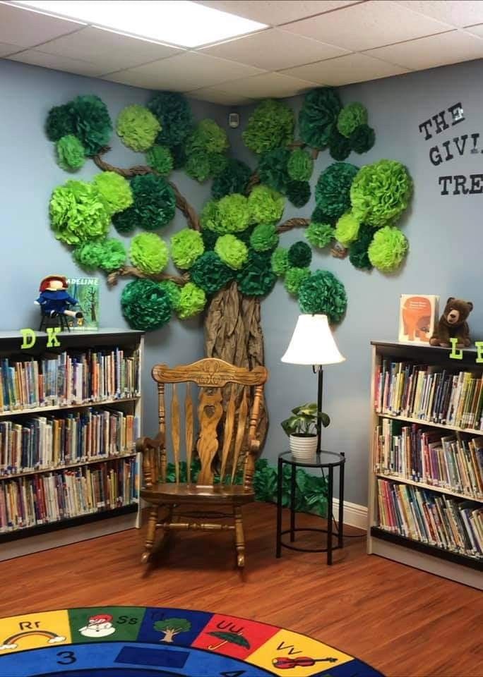 a room with bookshelves and a tree on the wall