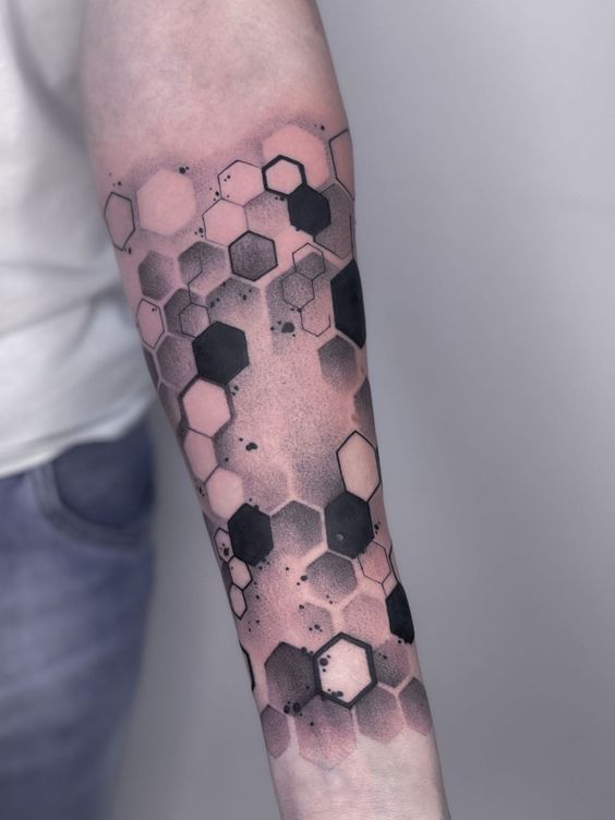 hexagonal tattoo on the arm with black and grey ink