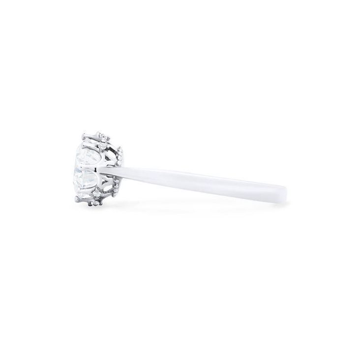 a white diamond ring with a single stone in the center on a white background,