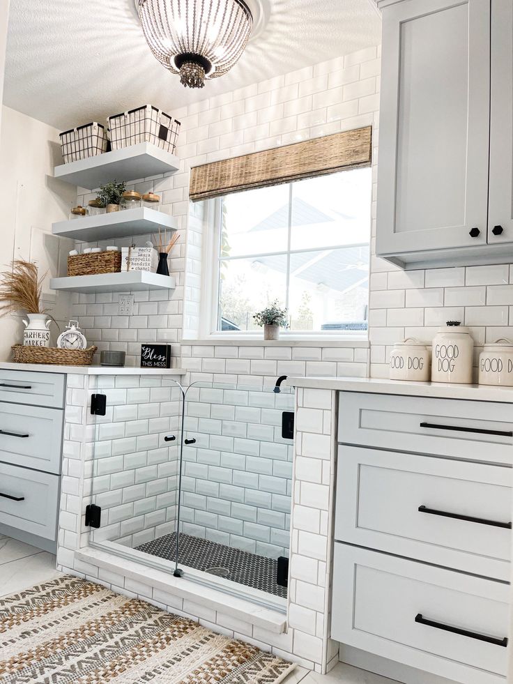 a kitchen with white cabinets and open shelvings on the wall, along with an area rug